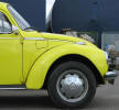 Een gele Volkswagen kever 1303 met bolle voorruit